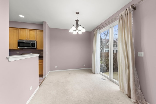 kitchen featuring hanging light fixtures, light carpet, and a chandelier