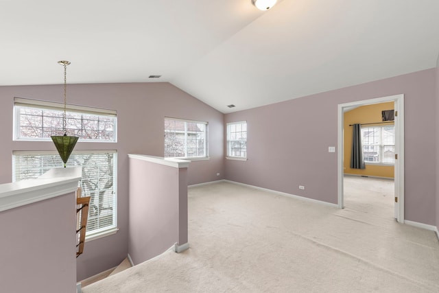 spare room featuring lofted ceiling and light carpet