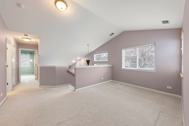 carpeted spare room featuring lofted ceiling