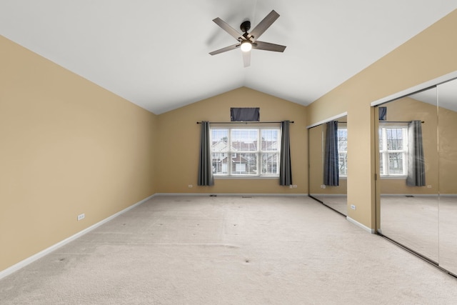 interior space with ceiling fan, light carpet, and vaulted ceiling