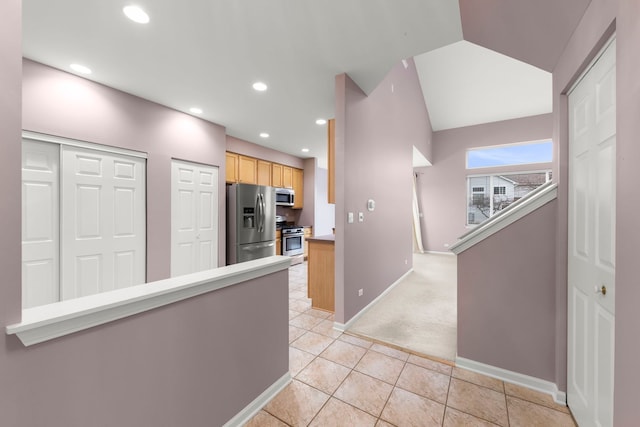 kitchen with light brown cabinetry, light colored carpet, and appliances with stainless steel finishes