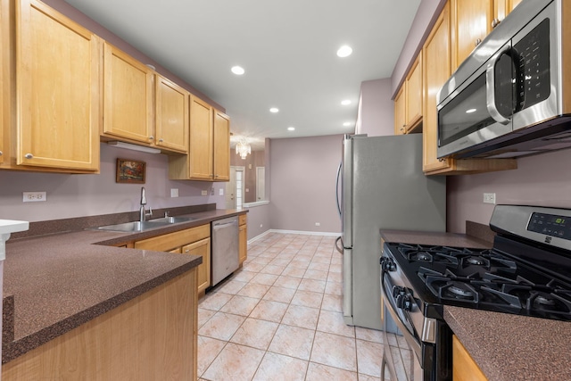 kitchen with sink, light tile patterned floors, light brown cabinets, and appliances with stainless steel finishes