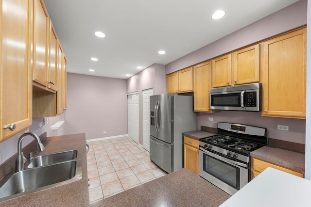 kitchen featuring light tile patterned floors, stainless steel appliances, light brown cabinetry, and sink