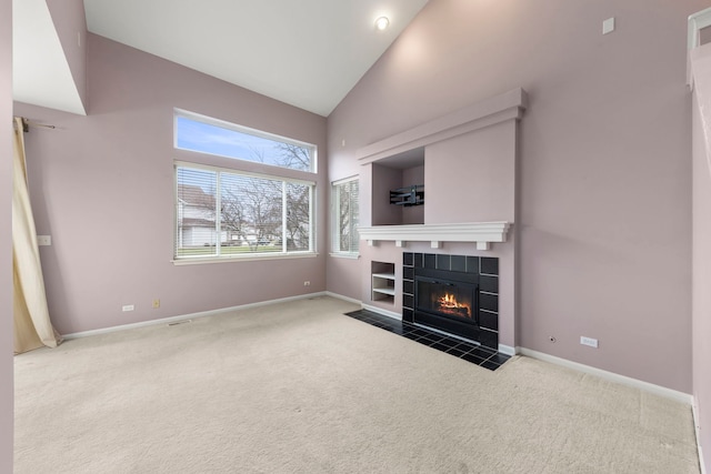 unfurnished living room featuring carpet floors, a fireplace, and high vaulted ceiling