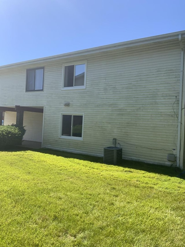 back of property featuring a lawn and central AC unit