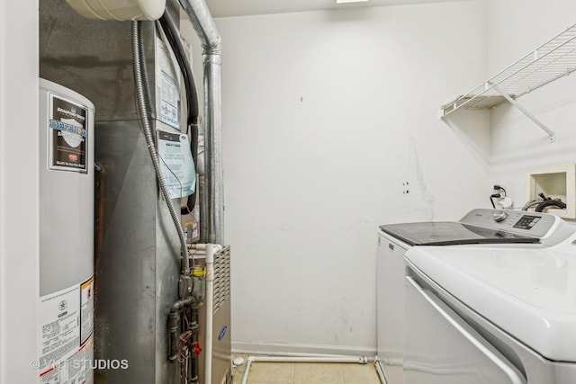 clothes washing area with washer and clothes dryer and water heater