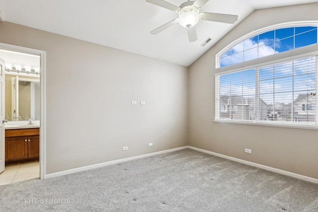 unfurnished bedroom with light carpet, ceiling fan, connected bathroom, lofted ceiling, and sink