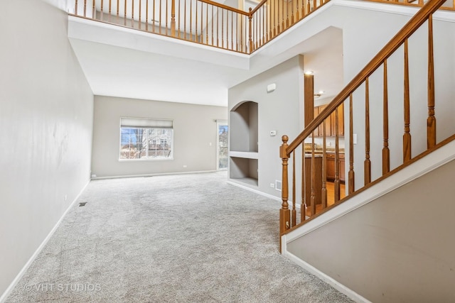 carpeted foyer with a high ceiling