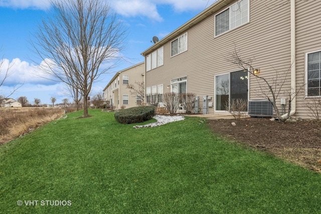 rear view of property with cooling unit and a yard