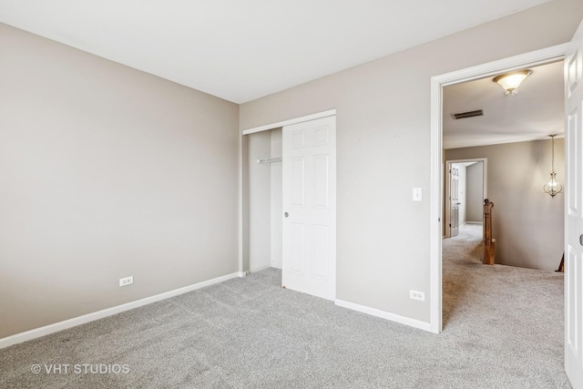 unfurnished bedroom featuring light carpet and a closet