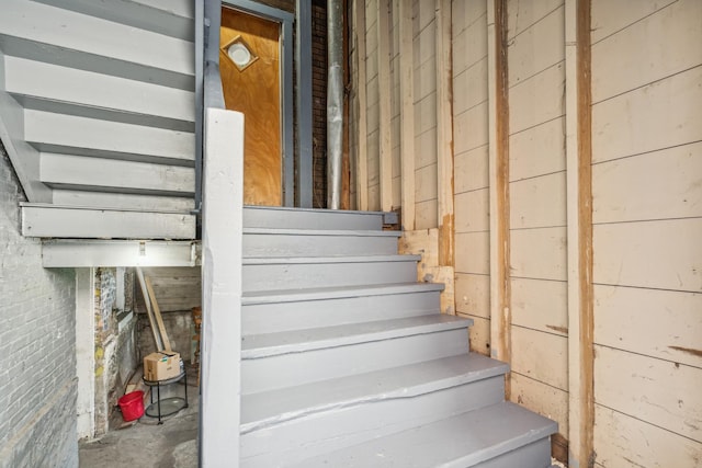 staircase with wood walls