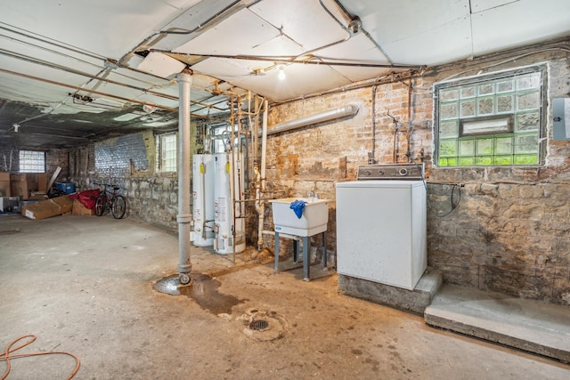 basement featuring gas water heater, electric panel, washer / clothes dryer, and sink