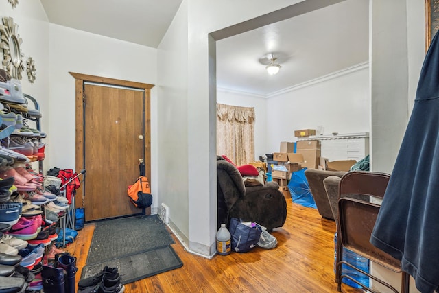 entrance foyer featuring wood-type flooring and ornamental molding