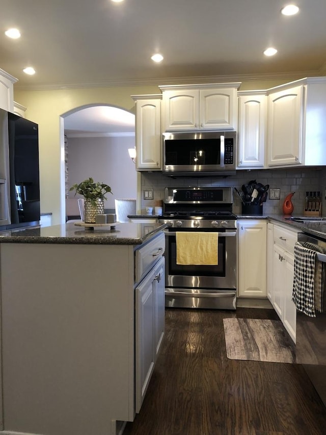 kitchen featuring white cabinets, appliances with stainless steel finishes, and backsplash