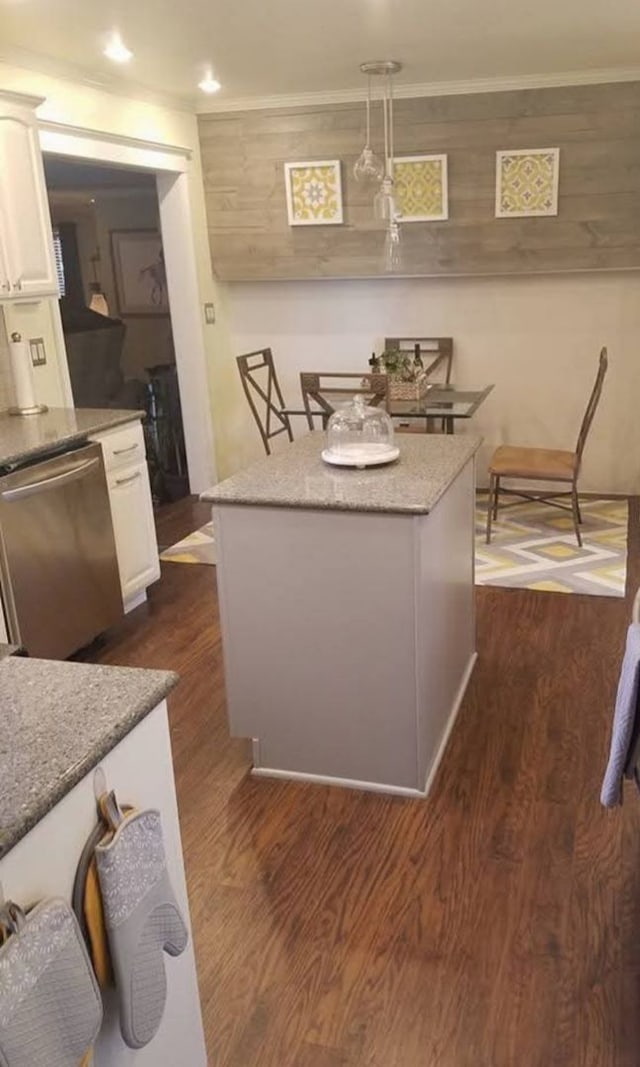 kitchen featuring decorative light fixtures, white cabinetry, stainless steel dishwasher, and dark hardwood / wood-style floors