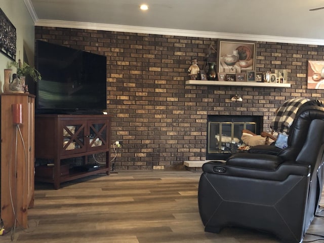 living room with a fireplace, hardwood / wood-style floors, ornamental molding, and brick wall