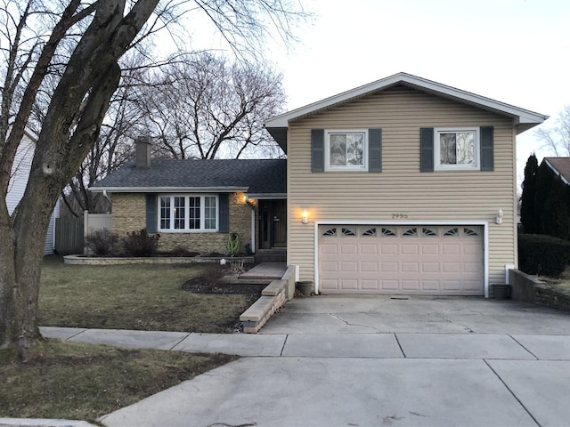 split level home with a garage and a front yard