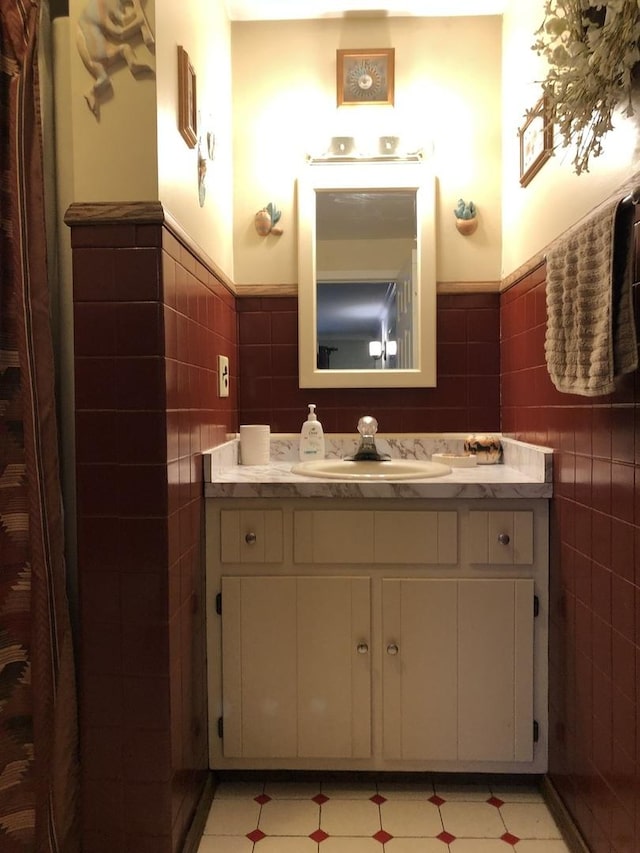 bathroom with vanity and tile walls