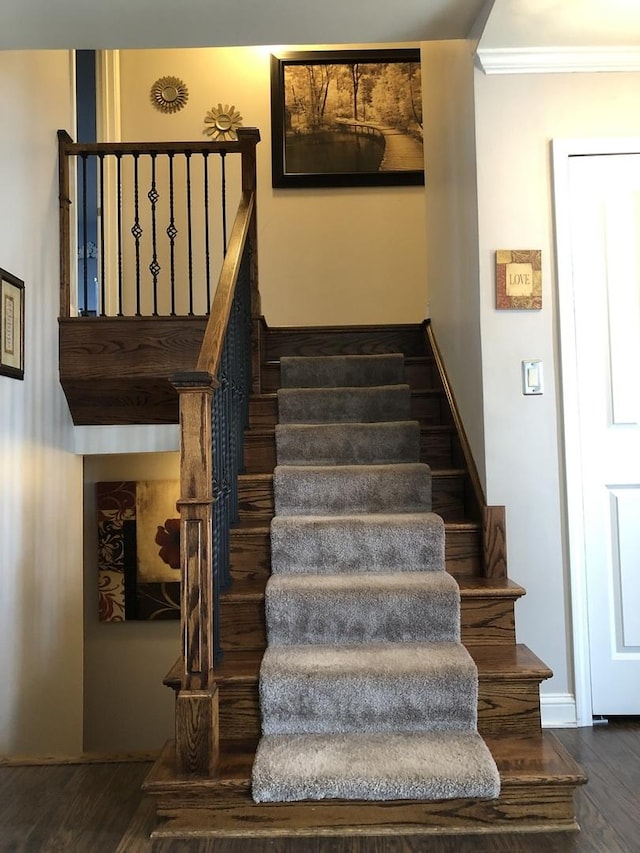 stairs featuring hardwood / wood-style floors and crown molding