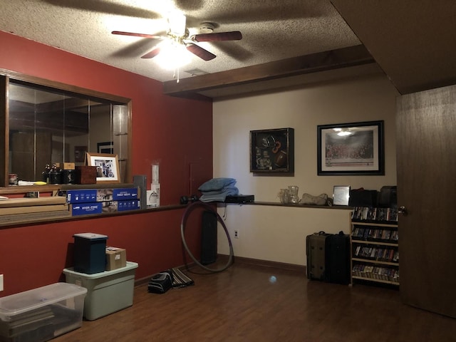 interior space featuring beamed ceiling, a textured ceiling, hardwood / wood-style flooring, and ceiling fan