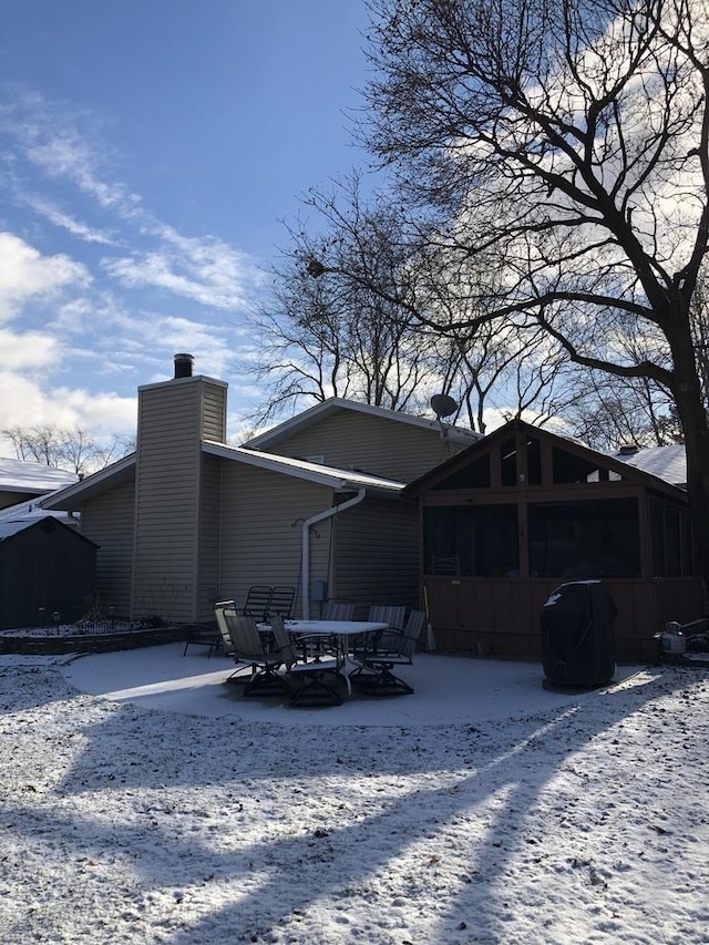 snow covered house with a sunroom