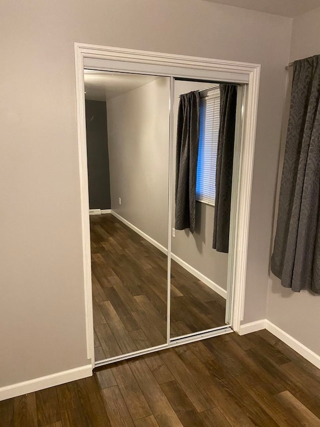 unfurnished bedroom featuring dark hardwood / wood-style flooring and a closet