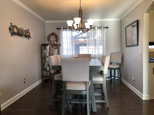 dining space featuring ornamental molding, dark hardwood / wood-style floors, and a notable chandelier