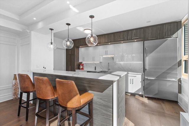 kitchen with dark brown cabinetry, white cabinetry, kitchen peninsula, and high quality fridge