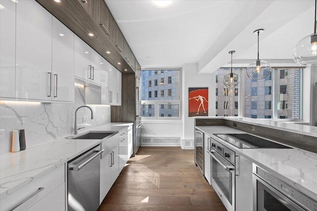 kitchen featuring white cabinetry, sink, dark wood-type flooring, decorative backsplash, and appliances with stainless steel finishes