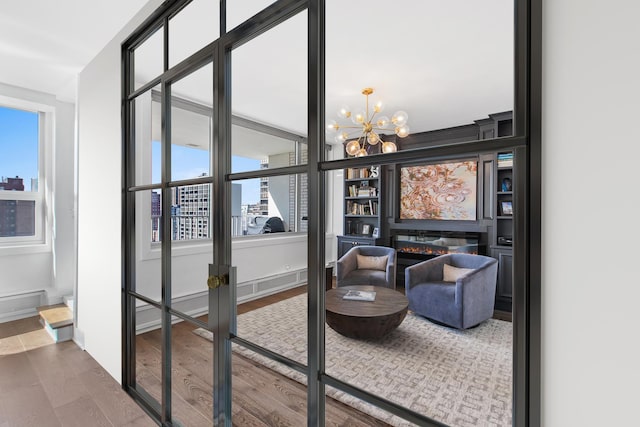 living area with hardwood / wood-style floors, a notable chandelier, and a healthy amount of sunlight