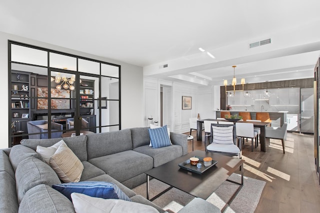 living room featuring hardwood / wood-style floors, a notable chandelier, and a tray ceiling