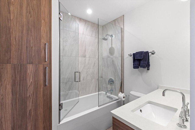 full bathroom featuring vanity, toilet, and shower / bath combination with glass door