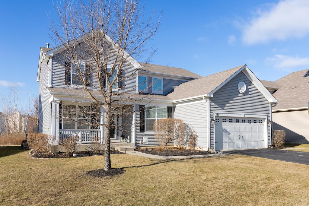 front of property featuring a porch, a garage, and a front lawn