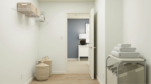 laundry area with light hardwood / wood-style floors