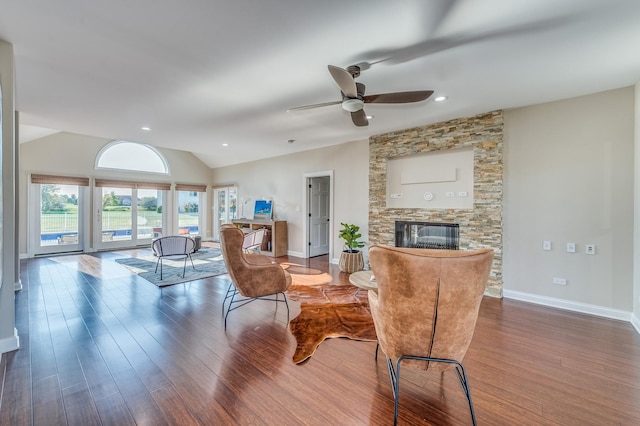 living room featuring a stone fireplace, ceiling fan, dark hardwood / wood-style flooring, and lofted ceiling