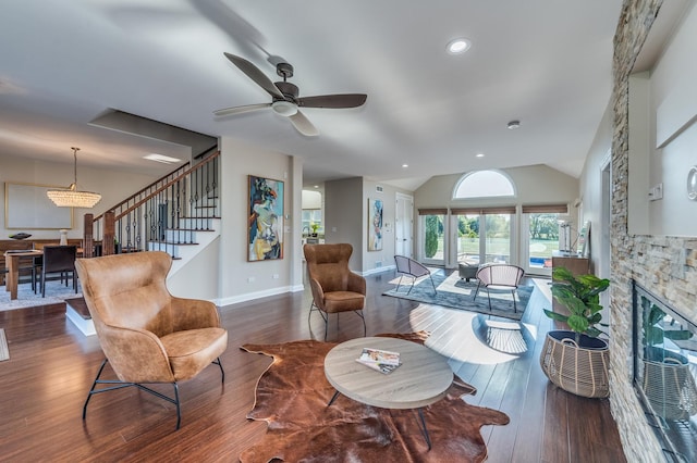 living room featuring vaulted ceiling, a stone fireplace, ceiling fan, and dark hardwood / wood-style floors