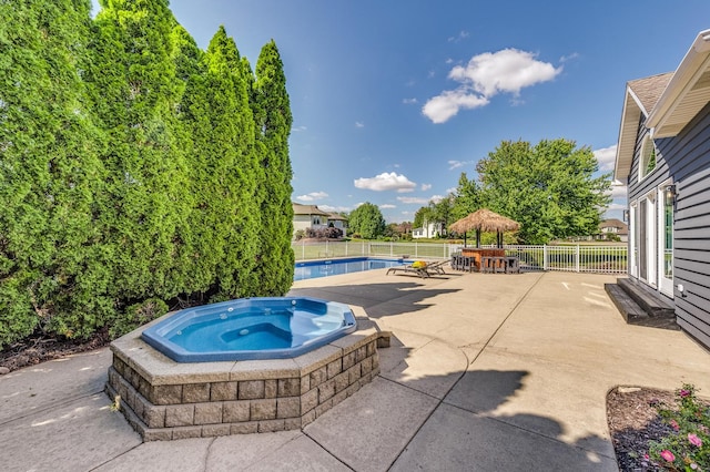 view of patio / terrace featuring a swimming pool with hot tub