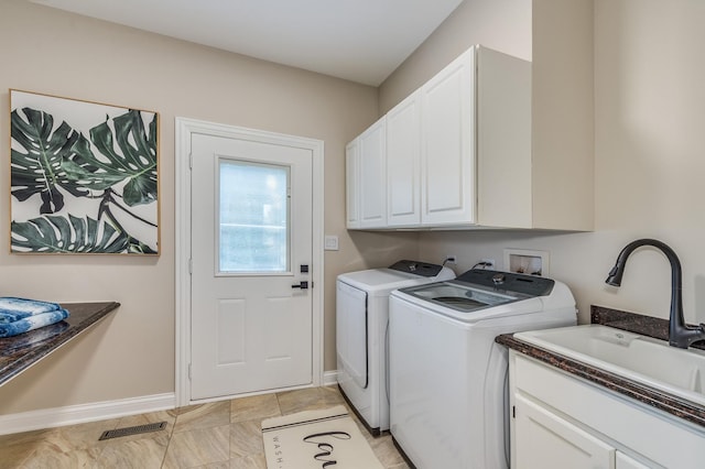 laundry area with washing machine and dryer, sink, and cabinets