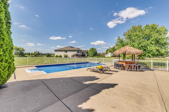 view of pool with exterior bar and a patio