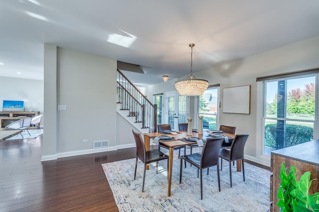 dining area featuring a chandelier, french doors, and dark wood-type flooring