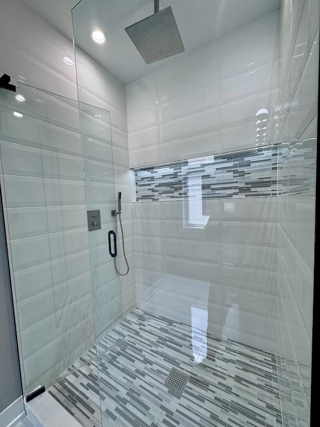 bathroom with a shower with door