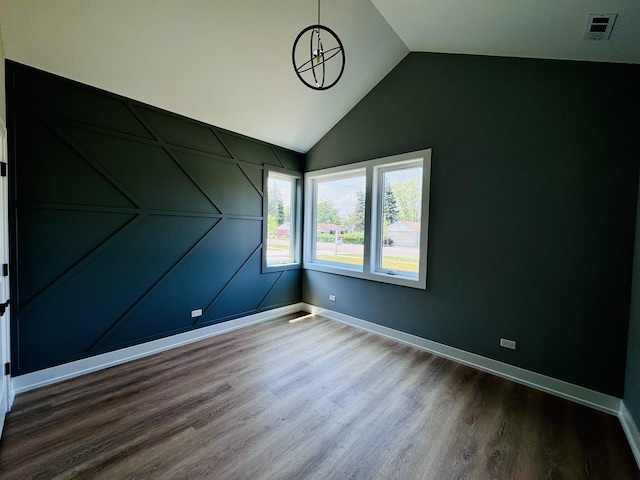 unfurnished room with lofted ceiling and hardwood / wood-style flooring