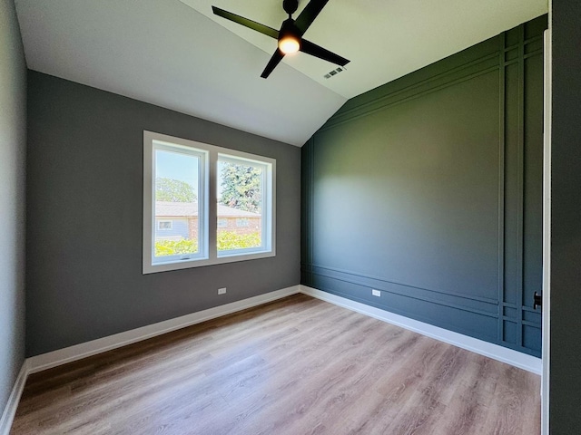 unfurnished room with ceiling fan, light wood-type flooring, and vaulted ceiling