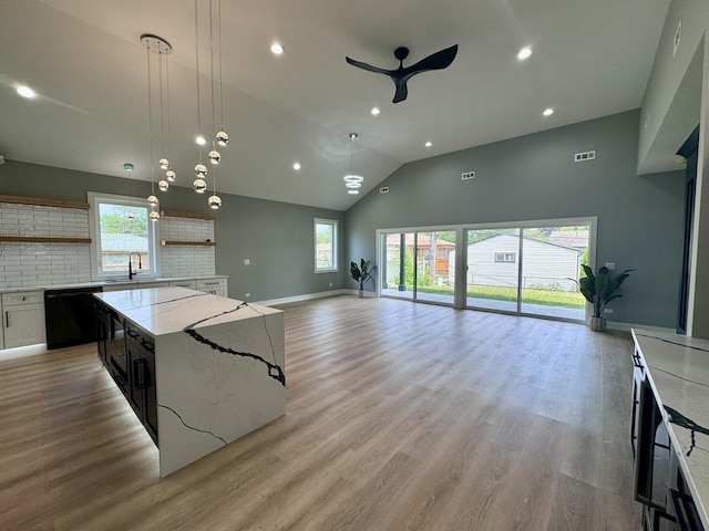 kitchen with pendant lighting, backsplash, white cabinets, ceiling fan, and black dishwasher