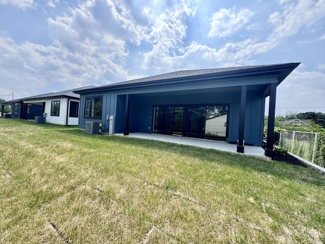 back of property with a yard and central AC unit