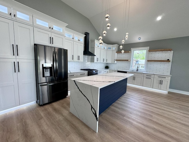 kitchen featuring backsplash, wall chimney exhaust hood, white cabinetry, and stainless steel appliances