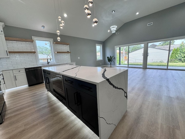 kitchen with a center island, dishwasher, hanging light fixtures, decorative backsplash, and white cabinets