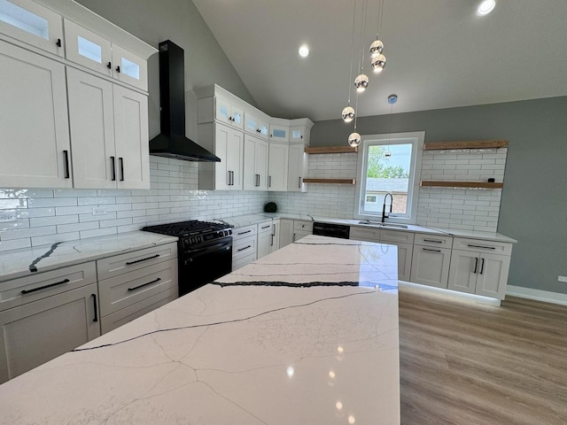 kitchen featuring white cabinetry, wall chimney exhaust hood, and black appliances