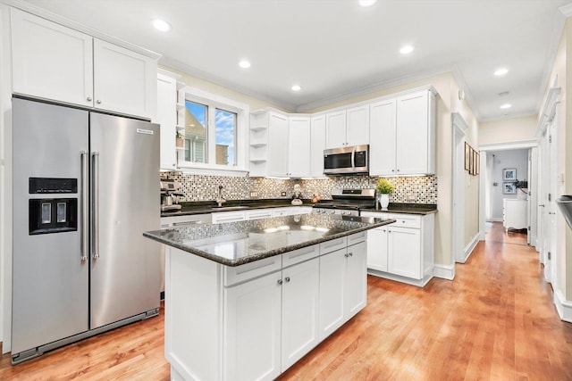 kitchen featuring dark stone counters, light hardwood / wood-style flooring, white cabinets, and stainless steel appliances