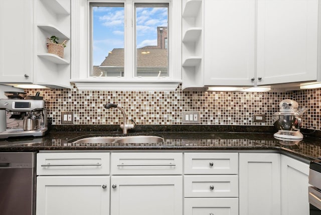 kitchen with dishwasher, dark stone countertops, white cabinetry, and tasteful backsplash